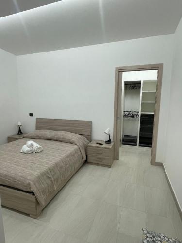 ein weißes Schlafzimmer mit Bett und Spiegel in der Unterkunft Il Pizzuto - Appartamento da Nonno Dino in Bernalda