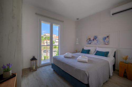 een slaapkamer met een groot bed en een groot raam bij VICANTI Luxury Apartments in Pylos