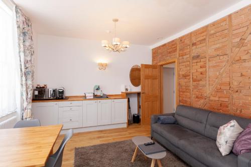 een woonkamer met een bank en een keuken bij Apartment 4 at Number 8 in City centre with kitchenette in Kent