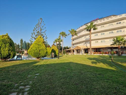 a large building with a park in front of it at Regina Hotel in Kissamos