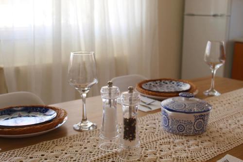 a table with two wine glasses and plates on it at paloma in Myrina