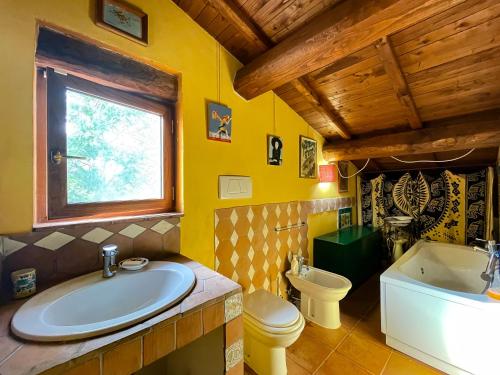 uma casa de banho com uma banheira, um lavatório e um WC. em Country House tra lago e mare a Sud di Roma em Campoleone