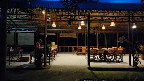 a dining area with tables and chairs and lights at Ba Danh Homestay & Kitchen - Ben Tre Mekong in Ben Tre