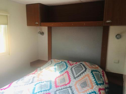 塞里尼昂的住宿－Mobil-home sur terrain privé，一间卧室配有一张带木制床头板的床