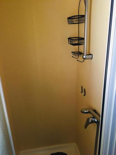 La salle de bains est pourvue d'une douche et de 3 paniers sur le mur. dans l'établissement Mobil-home sur terrain privé, à Sérignan