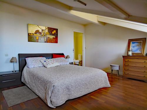 um quarto com uma cama grande e uma cómoda. em L'OASIS - Loft standing - Terrasse Rooftop - Jacuzzi Spa - Parking em Baiona