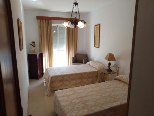 a hotel room with two beds and a window at Luz in Chiclana de la Frontera