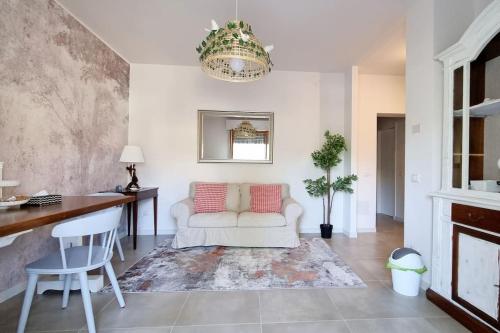 a living room with a white couch and a table at Via Guareschi in Fontanelle di Roccabianca