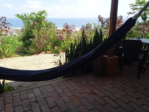 a hammock on a patio with the ocean in the background at Punto Verde Ecological house in Montañita