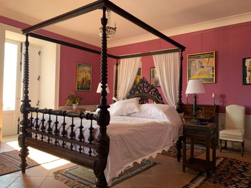 a bedroom with a large canopy bed and a desk at Palazzo Carratelli in Amantea