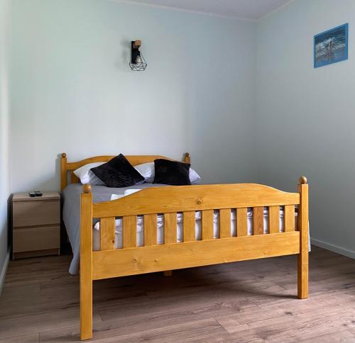 a wooden bed with two pillows on it in a room at Dolores in Giżycko