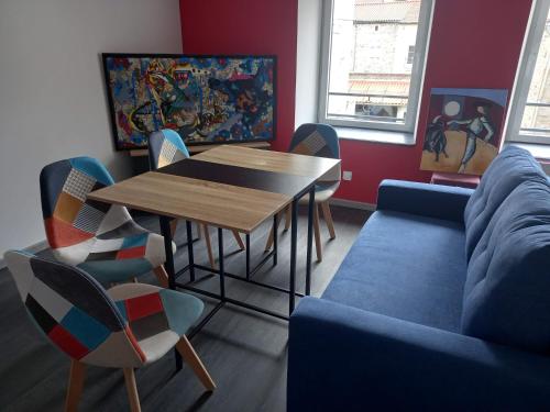 un salon avec une table, des chaises et un canapé dans l'établissement La Remise de SoSo, à Chambon-le-Château
