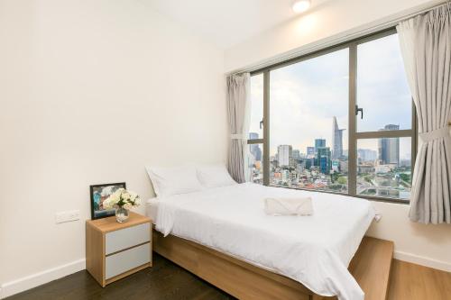 um quarto com uma cama e uma grande janela em YO's Homes Rivergate Apartment Infinity Pool Near District 1 em Ho Chi Minh