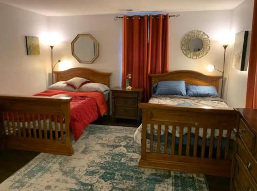 Un dormitorio con dos camas y un espejo. en The Redhawk Hideaway: Charming 2BR Condo near Miami Univ in Oxford! Book now!, en Oxford