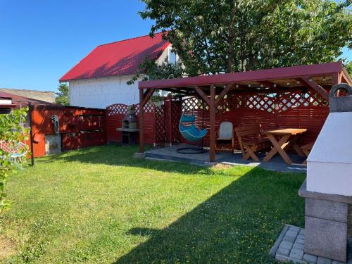 a picnic shelter with a table and chairs in a yard at Dom wypoczynkowy FENIX in Werblinia