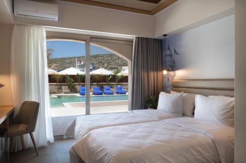 a bedroom with a bed and a view of a pool at Prasonisi Lighthouse Boutique Hotel in Prasonisi