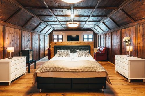 a bedroom with a large bed and wooden walls at Hotel Zlaty Andel in Český Krumlov