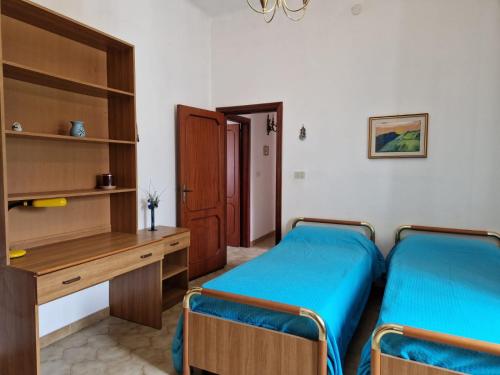 1 Schlafzimmer mit 2 Einzelbetten und einem Schreibtisch in der Unterkunft VILLA TERESA IRIS e Ibisco in Giovinazzo