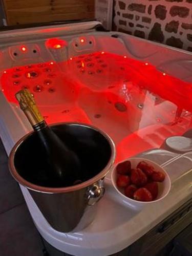 a bottle of wine in a bucket next to a bowl of strawberries at la caliente in Saint-Mars-sur-la-Futaie