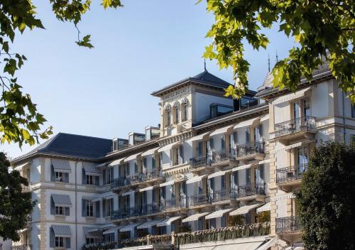 a large white building with balconies at Grand Hotel du Lac - Relais & Châteaux in Vevey