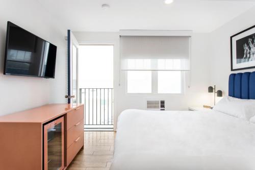 a bedroom with a large bed and a tv at Grove Hotel in Cherry Grove