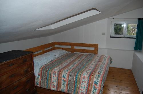 a bedroom with a bed and a dresser and a window at Agriturismo Cele in Celle Ligure