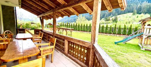 a porch with a table and chairs and a playground at Pensiunea Ioana in Sadova