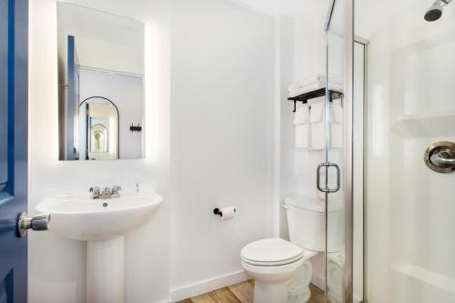 a white bathroom with a sink and a toilet at Grove Hotel in Cherry Grove