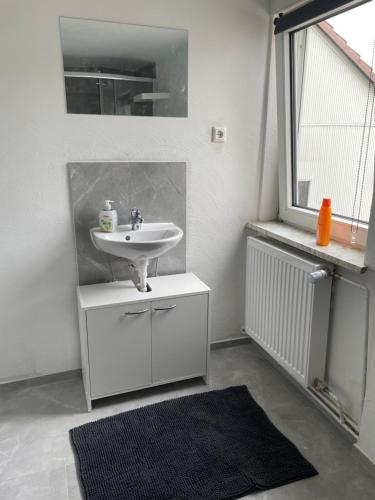 Ferienwohnung Monteurwohnungen Kassel Zentral lll في كاسيل: حمام أبيض مع حوض ومرآة