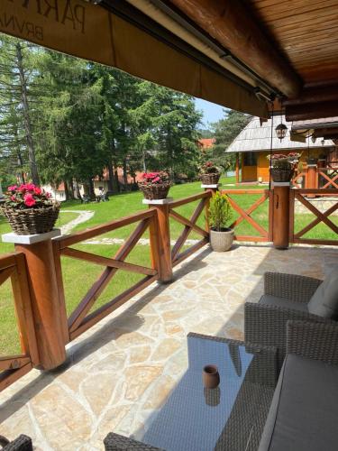 a patio with a wooden fence and some plants at Brvnare Park Borova in Zlatibor
