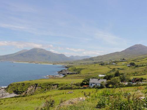 a house on a hill next to a body of water at Old Mike's Cottage in Westport