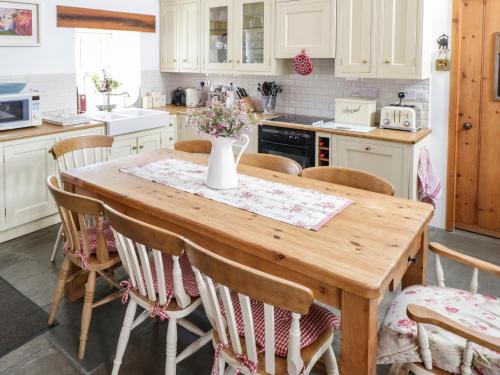 a kitchen with a wooden table and chairs at Old Mike's Cottage in Westport