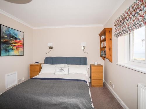 Schlafzimmer mit einem Bett und einem Fenster in der Unterkunft 7 Min Y Traeth in Pwllheli