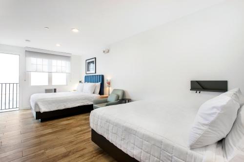 a hotel room with two beds and a television at Grove Hotel in Cherry Grove