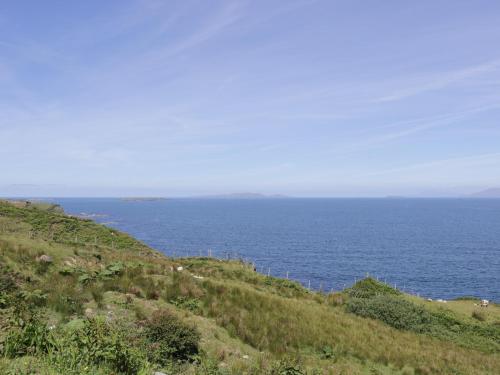 a view of the ocean from the side of a hill at Old Mike's Cottage in Westport