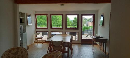 uma sala de estar com uma mesa, cadeiras e janelas em Weingut Fehres em Brauneberg