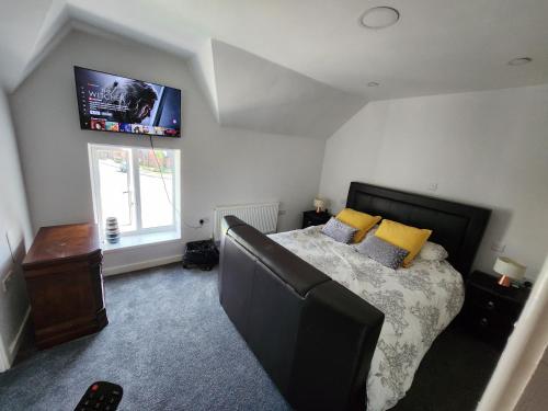 a bedroom with a bed and a tv on the wall at Woodborough road close to city in Nottingham