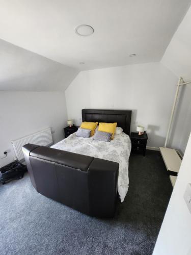 a bedroom with a bed and a black leather couch at Woodborough road close to city in Nottingham