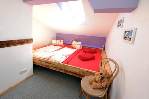 ein kleines Schlafzimmer mit einem Teddybär auf einem Stuhl in der Unterkunft Appartment Eggerhof in Saalfelden am Steinernen Meer