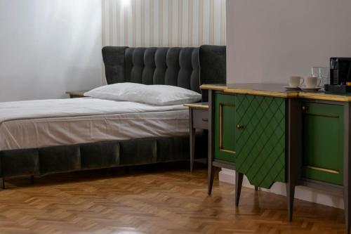 a bedroom with a bed and a green cabinet at Sia Boutique Aparthotel in Sibiu