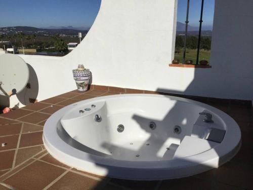 a white bath tub in a bathroom with a window at Golf&sea views townhouse. in San Roque