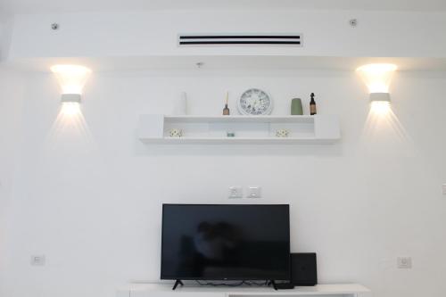 a living room with two lights and a flat screen tv at Beach Suite Israel - Indoor Pool, Best View, Gym, Massage Chair, Spa ביץ סוייט ישראל - נוף ים מאלף, בריכה מקורה, כיסא מסאז, חדר כושר וספא in Ashqelon