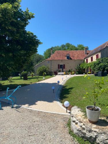 a driveway with a plant in a pot next to a house at Le Domaine du Gravier in Gramat
