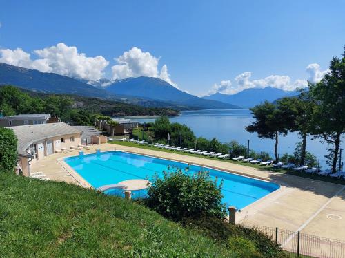 a large swimming pool with a view of a lake at leparadisachorges in Chorges