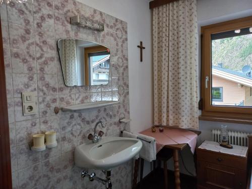 ein Bad mit einem Waschbecken und einem Spiegel in der Unterkunft Ferienwohnungen Plattner in Längenfeld