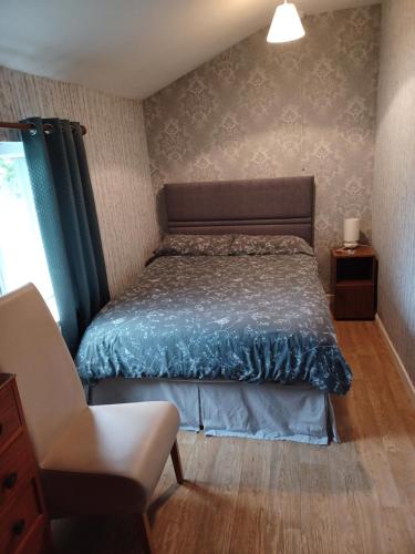 a bedroom with a bed and a chair at Hill view Cottage in Curr