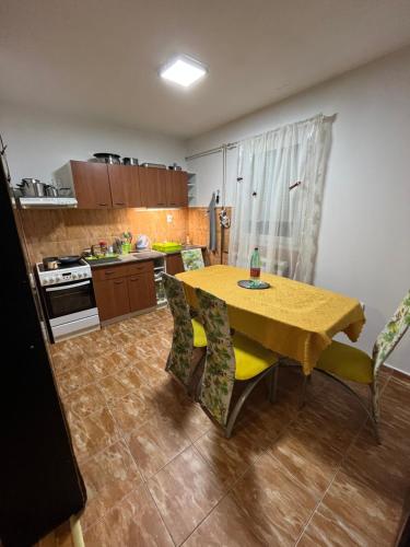 een keuken met een tafel en stoelen in een kamer bij Gugi House in Borča