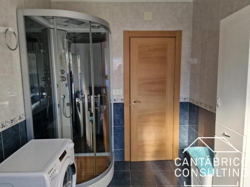 a bathroom with a washing machine and a wooden door at Casa "LA OCA" - Planta Baja Independiente en Vivienda Independiente in Andés