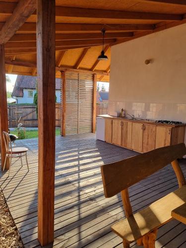 a wooden deck with a kitchen and a bench at Pokoje Apartament LUX in Mikołajki