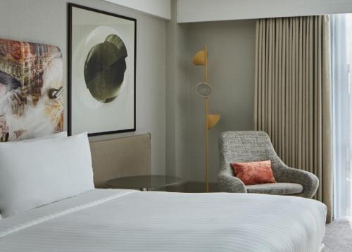 a hotel room with a bed and a chair at London Marriott Hotel Kensington in London
